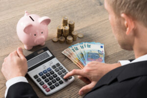 電卓で費用を計算する男
