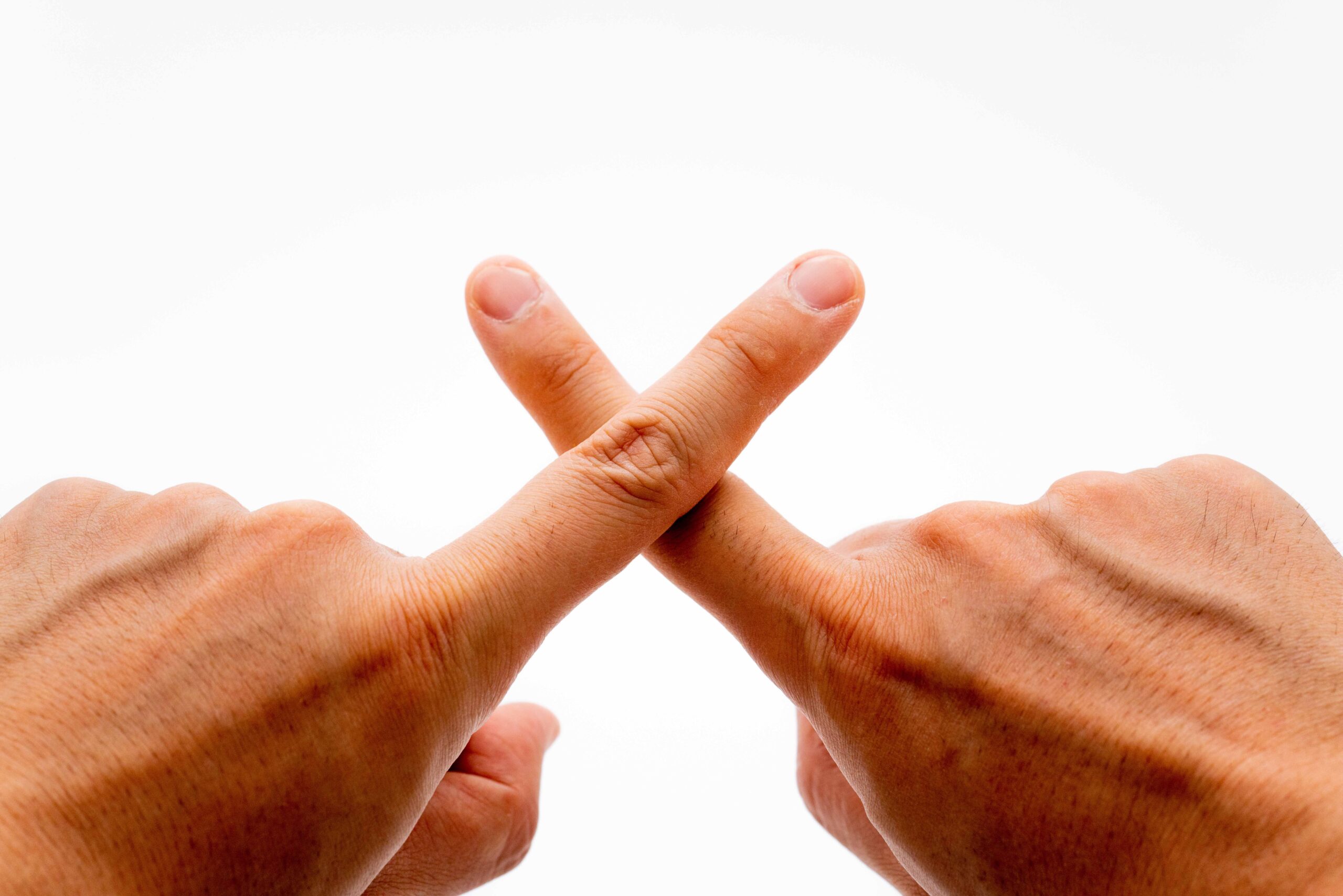 両手の人差し指でバツを作っている